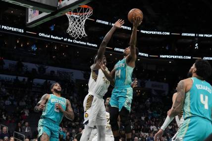 Feb 4, 2024; Charlotte, North Carolina, USA; Charlotte Hornets guard Ish Smith (14) gets a fast break basket defended by Indiana Pacers forward Aaron Nesmith (23) during the first quarter at Spectrum Center. Mandatory Credit: Jim Dedmon-USA TODAY Sports