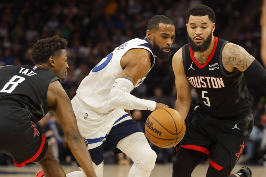 Feb 4, 2024; Minneapolis, Minnesota, USA; Minnesota Timberwolves guard Mike Conley (10) drives between Houston Rockets forward Jae'Sean Tate (8) and guard Fred VanVleet (5) in the first quarter at Target Center. Mandatory Credit: Bruce Kluckhohn-USA TODAY Sports