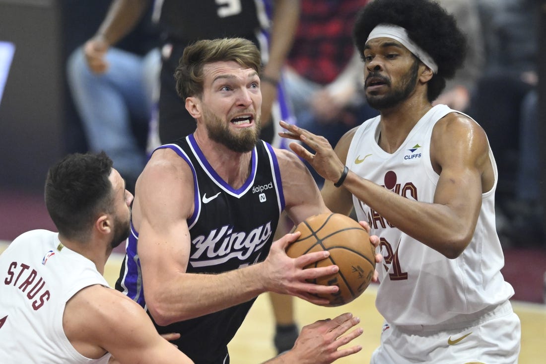 Feb 5, 2024; Cleveland, Ohio, USA; Sacramento Kings forward Domantas Sabonis (10) drives between Cleveland Cavaliers guard Max Strus (1) and center Jarrett Allen (31) in the first quarter at Rocket Mortgage FieldHouse. Mandatory Credit: David Richard-USA TODAY Sports