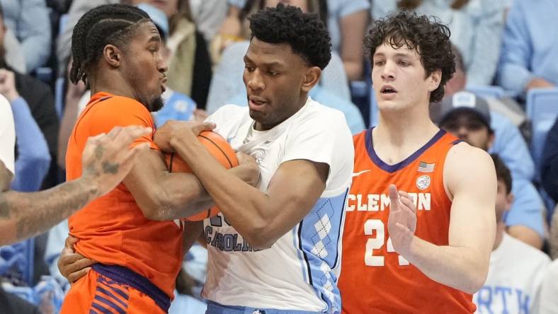 Feb 6, 2024; Chapel Hill, North Carolina, USA; North Carolina Tar Heels forward Jalen Washington (13) and Clemson Tigers forward Chauncey Wiggins (21) and Clemson Tigers center PJ Hall (24) fight for the ball in the first half at Dean E. Smith Center. Mandatory Credit: Bob Donnan-USA TODAY Sports