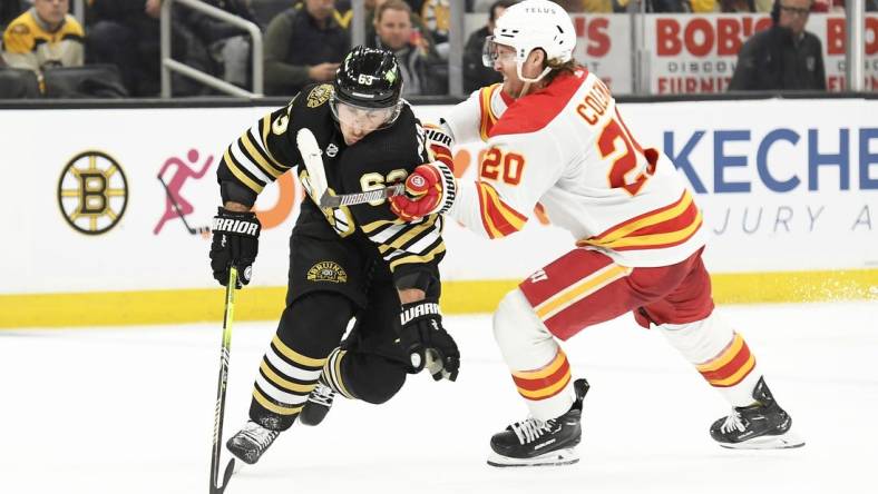 Feb 6, 2024; Boston, Massachusetts, USA; Boston Bruins left wing Brad Marchand (63) controls the puck from Calgary Flames center Blake Coleman (20) during the second period at TD Garden. Mandatory Credit: Bob DeChiara-USA TODAY Sports