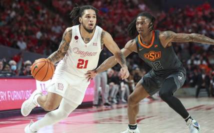 Feb 6, 2024; Houston, Texas, USA; Houston Cougars guard Emanuel Sharp (21) drives with the ball as Oklahoma State Cowboys guard Javon Small (12) defends during the second half at Fertitta Center. Mandatory Credit: Troy Taormina-USA TODAY Sports