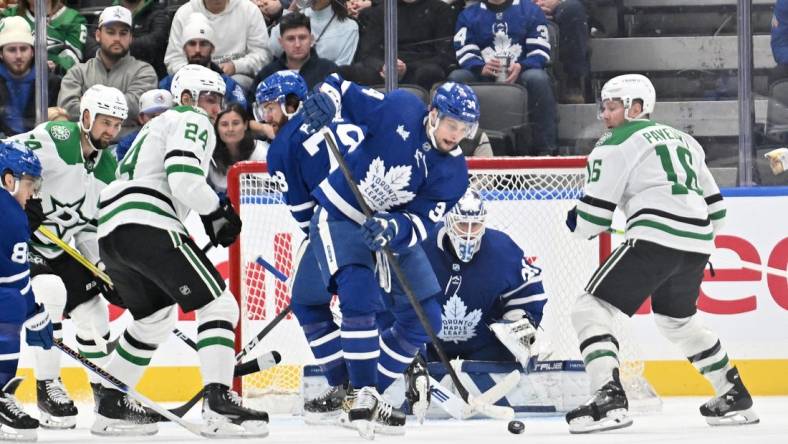 Feb 7, 2024; Toronto, Ontario, CAN; Toronto Maple Leafs forward Auston Matthews (34) clears the puck away from goalie Ilya Samsonov (35) as Dallas Stars forwards Joe Pavelski (16) and Roope Hintz (24) look on in the third period at Scotiabank Arena. Mandatory Credit: Dan Hamilton-USA TODAY Sports