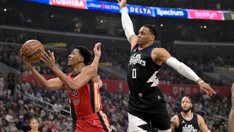 Feb 7, 2024; Los Angeles, California, USA; New Orleans Pelicans guard Jordan Hawkins (24) drives past Los Angeles Clippers guard Russell Westbrook (0) reach for a rebound in the first half at Crypto.com Arena. Mandatory Credit: Jayne Kamin-Oncea-USA TODAY Sports