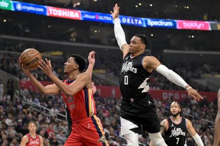 Feb 7, 2024; Los Angeles, California, USA; New Orleans Pelicans guard Jordan Hawkins (24) drives past Los Angeles Clippers guard Russell Westbrook (0) reach for a rebound in the first half at Crypto.com Arena. Mandatory Credit: Jayne Kamin-Oncea-USA TODAY Sports