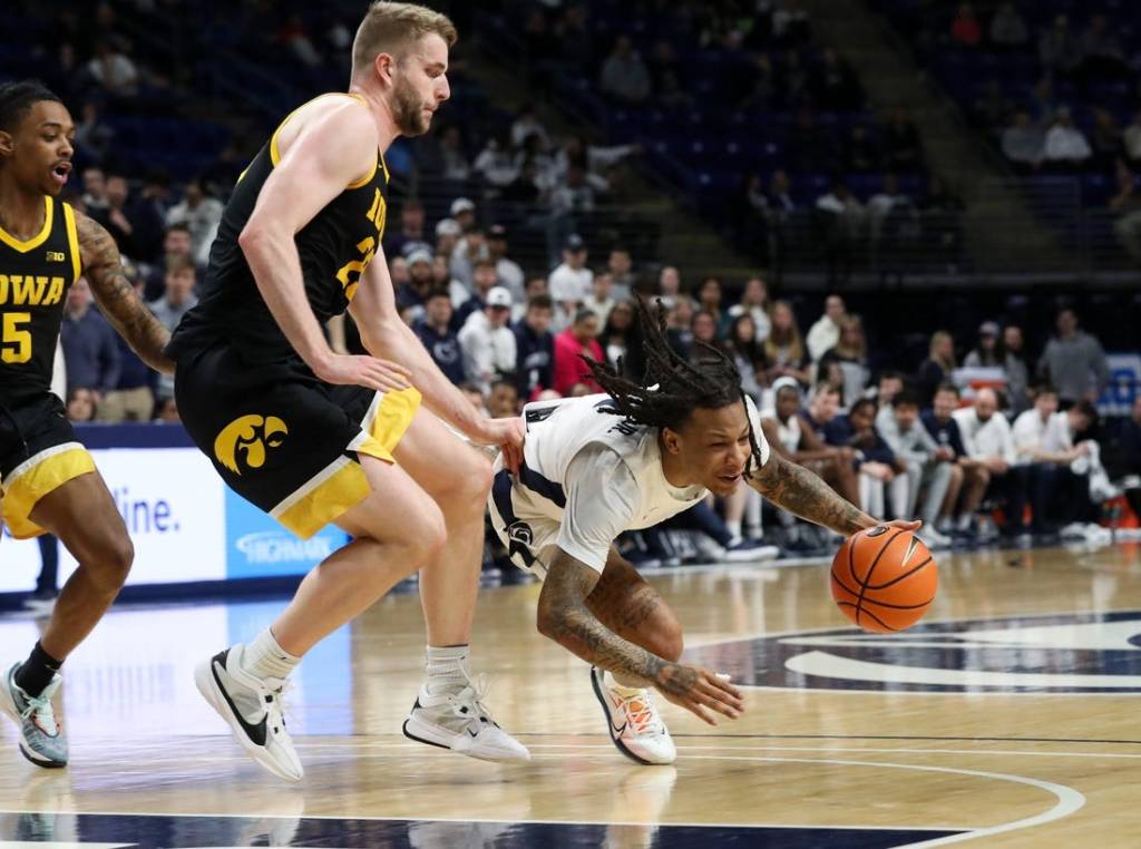 Feb 8, 2024; University Park, Pennsylvania, USA; Penn State Nittany Lions guard Ace Baldwin Jr (1) looses his footing while dribbling the ball around Iowa Hawkeyes forward Ben Krikke (23) during the first half at Bryce Jordan Center. Mandatory Credit: Matthew O'Haren-USA TODAY Sports