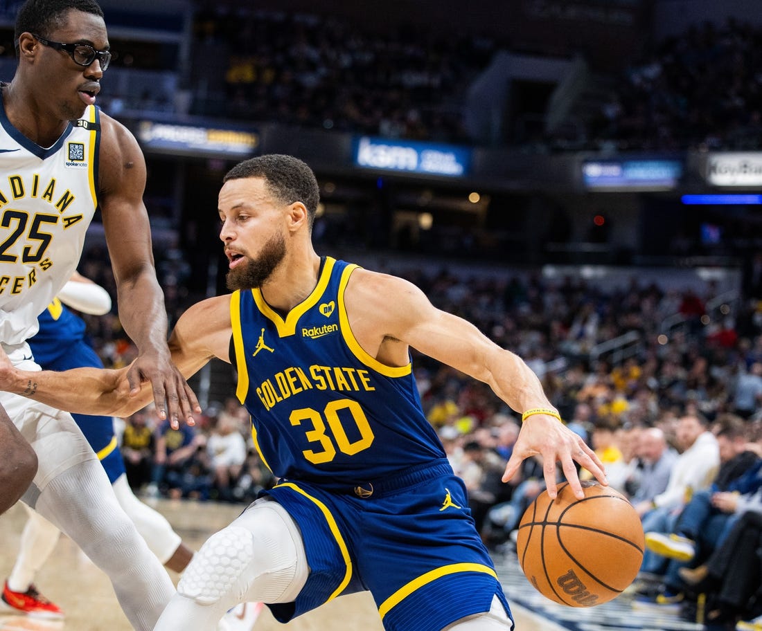 Feb 8, 2024; Indianapolis, Indiana, USA; Golden State Warriors guard Stephen Curry (30) dribbles the ball while Indiana Pacers forward Jalen Smith (25) defends in the first half at Gainbridge Fieldhouse. Mandatory Credit: Trevor Ruszkowski-USA TODAY Sports