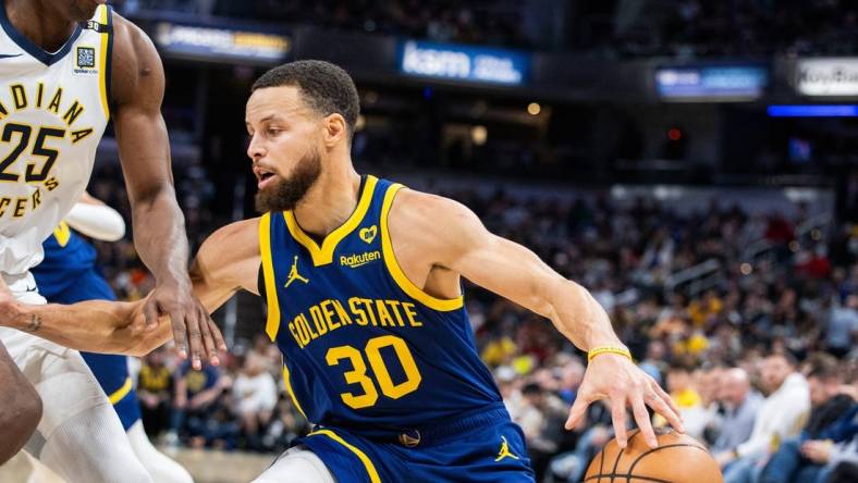 Feb 8, 2024; Indianapolis, Indiana, USA; Golden State Warriors guard Stephen Curry (30) dribbles the ball while Indiana Pacers forward Jalen Smith (25) defends in the first half at Gainbridge Fieldhouse. Mandatory Credit: Trevor Ruszkowski-USA TODAY Sports