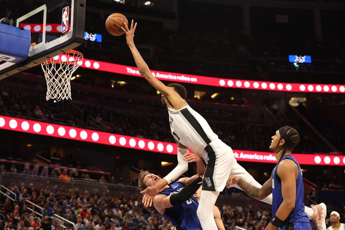 Feb 8, 2024; Orlando, Florida, USA;  Orlando Magic center Moritz Wagner (21) fouls San Antonio Spurs center Victor Wembanyama (1) during the second half at Kia Center. Mandatory Credit: Kim Klement Neitzel-USA TODAY Sports