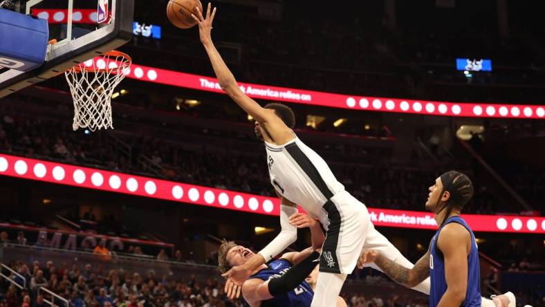 Feb 8, 2024; Orlando, Florida, USA;  Orlando Magic center Moritz Wagner (21) fouls San Antonio Spurs center Victor Wembanyama (1) during the second half at Kia Center. Mandatory Credit: Kim Klement Neitzel-USA TODAY Sports