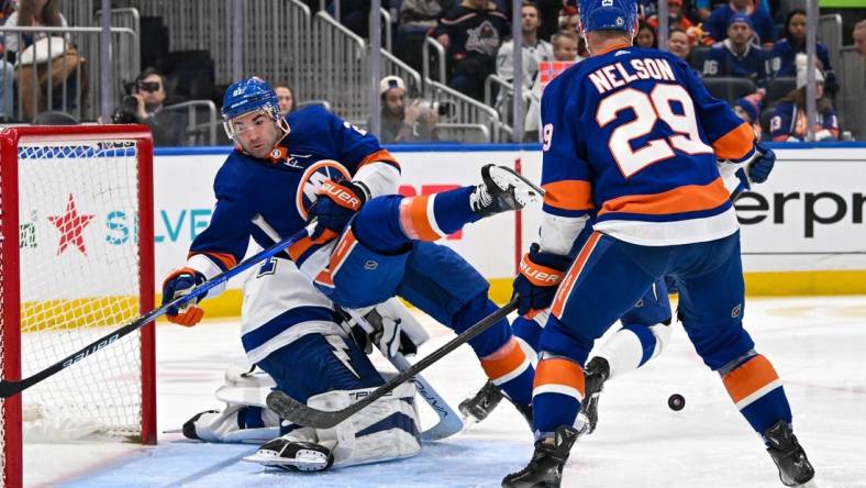 Feb 8, 2024; Elmont, New York, USA; New York Islanders center Kyle Palmieri (21) falls over Tampa Bay Lightning goaltender Jonas Johansson (31) during the second period at UBS Arena. Mandatory Credit: Dennis Schneidler-USA TODAY Sports