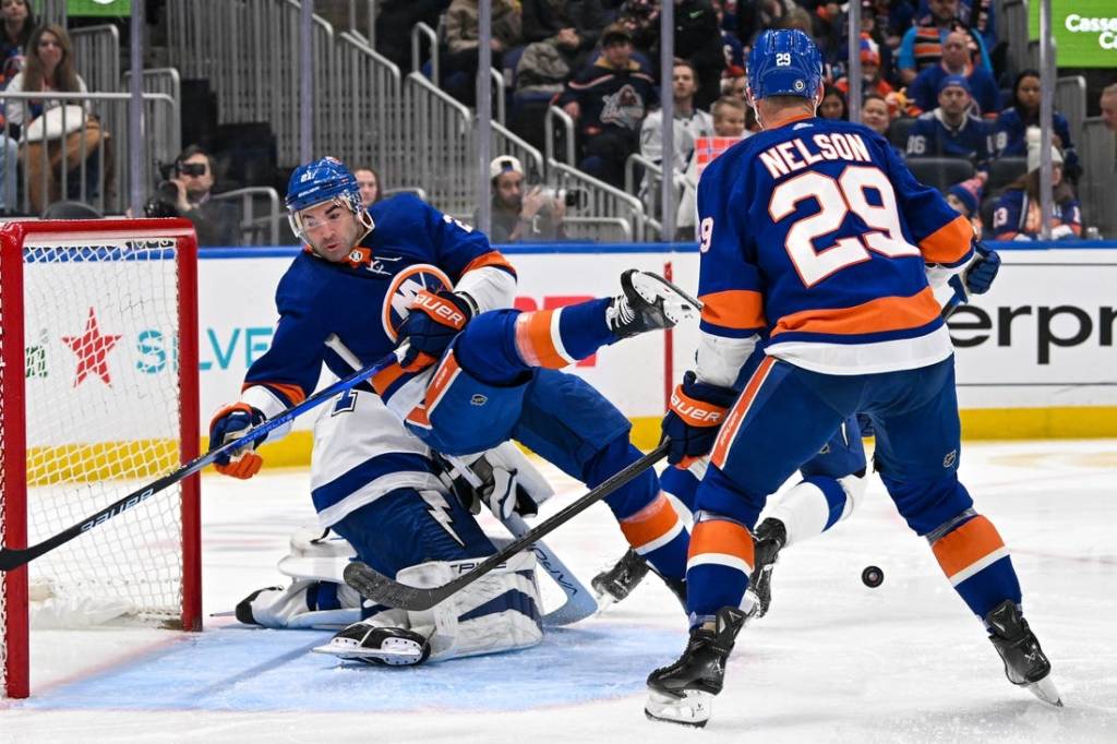 Feb 8, 2024; Elmont, New York, USA; New York Islanders center Kyle Palmieri (21) falls over Tampa Bay Lightning goaltender Jonas Johansson (31) during the second period at UBS Arena. Mandatory Credit: Dennis Schneidler-USA TODAY Sports