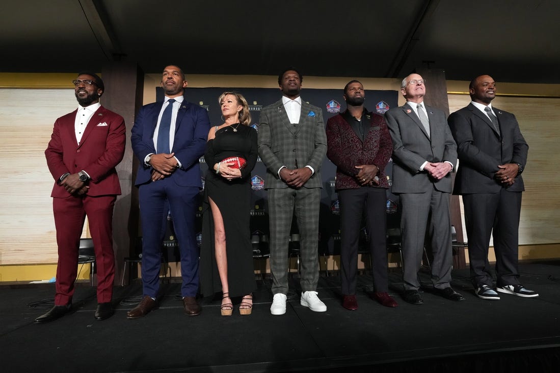 Feb 8, 2024; Las Vegas, NV, USA; Pro Football Hall of Fame Class of 2024 inductees pose at press conference at the Resorts World Theatre. From left: Patrick Willis, Julius Peppers, Misty McMichael (representing Steve McMichael), Andre Johnson, Devin Hester, Randy Grdishar and Dwight Freeney. Mandatory Credit: Kirby Lee-USA TODAY Sports