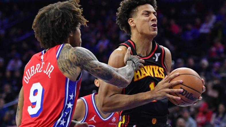 Feb 9, 2024; Philadelphia, Pennsylvania, USA; Atlanta Hawks forward Jalen Johnson (1) drives past Philadelphia 76ers guard Kelly Oubre Jr. (9) during the first quarter at Wells Fargo Center. Mandatory Credit: Eric Hartline-USA TODAY Sports