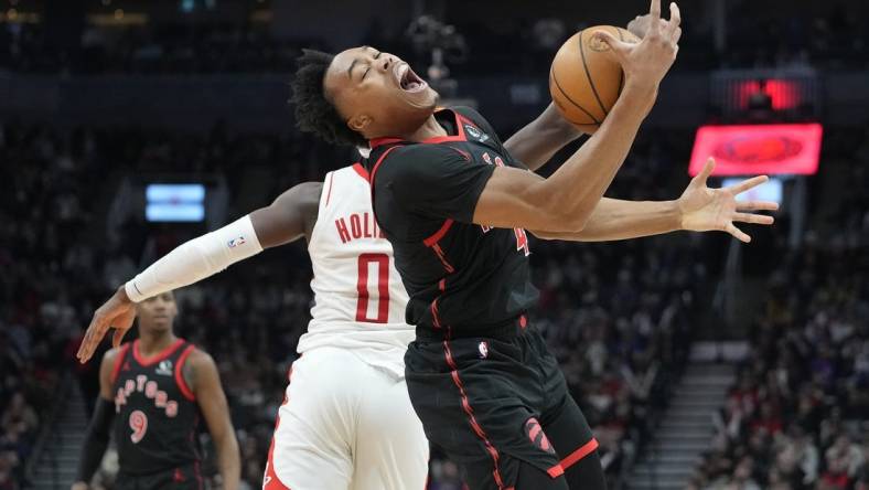 Feb 9, 2024; Toronto, Ontario, CAN; Toronto Raptors forward Scottie Barnes (4) pulls in a pass against Houston Rockets guard Aaron Holiday (0) during the first half at Scotiabank Arena. Mandatory Credit: John E. Sokolowski-USA TODAY Sports