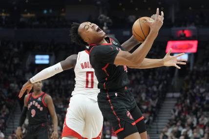 Feb 9, 2024; Toronto, Ontario, CAN; Toronto Raptors forward Scottie Barnes (4) pulls in a pass against Houston Rockets guard Aaron Holiday (0) during the first half at Scotiabank Arena. Mandatory Credit: John E. Sokolowski-USA TODAY Sports