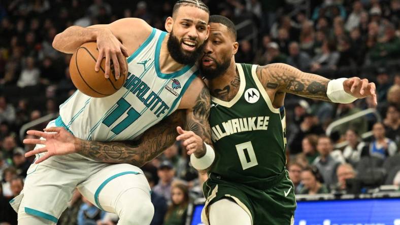 Feb 9, 2024; Milwaukee, Wisconsin, USA; Charlotte Hornets forward Cody Martin (11) drives to the basket against Milwaukee Bucks guard Damian Lillard (0) in the first half at Fiserv Forum. Mandatory Credit: Michael McLoone-USA TODAY Sports