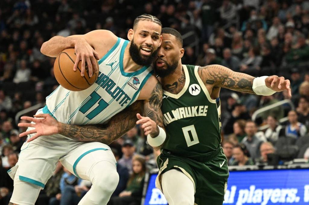 Feb 9, 2024; Milwaukee, Wisconsin, USA; Charlotte Hornets forward Cody Martin (11) drives to the basket against Milwaukee Bucks guard Damian Lillard (0) in the first half at Fiserv Forum. Mandatory Credit: Michael McLoone-USA TODAY Sports