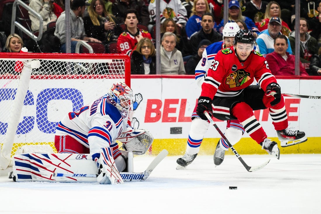 Feb 9, 2024; Chicago, Illinois, USA; Chicago Blackhawks center Philipp Kurashev (23) jumps off the ice as New York Rangers goaltender Igor Shesterkin (31) defends his goal during the first period at the United Center. Mandatory Credit: Daniel Bartel-USA TODAY Sports