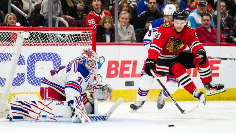 Feb 9, 2024; Chicago, Illinois, USA; Chicago Blackhawks center Philipp Kurashev (23) jumps off the ice as New York Rangers goaltender Igor Shesterkin (31) defends his goal during the first period at the United Center. Mandatory Credit: Daniel Bartel-USA TODAY Sports