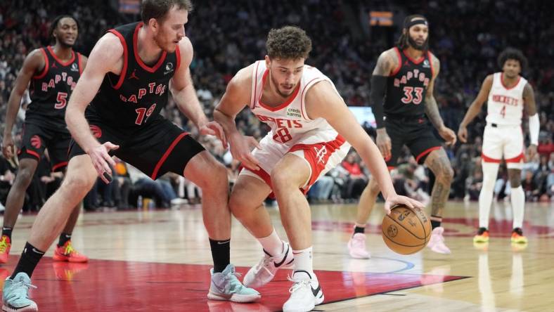 Feb 9, 2024; Toronto, Ontario, CAN; Houston Rockets center Alperen Sengun (28) controls the ball against Toronto Raptors center Jakob Poeltl (19) during the second half at Scotiabank Arena. Mandatory Credit: John E. Sokolowski-USA TODAY Sports