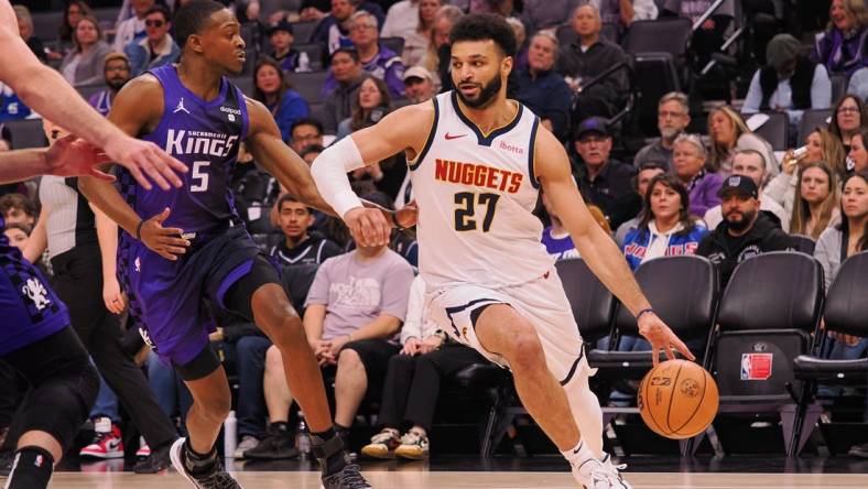 Feb 9, 2024; Sacramento, California, USA; Denver Nuggets guard Jamal Murray (27) controls the ball against Sacramento Kings guard De'Aaron Fox (5) during the first quarter at Golden 1 Center. Mandatory Credit: Kelley L Cox-USA TODAY Sports