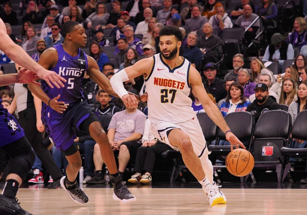 Feb 9, 2024; Sacramento, California, USA; Denver Nuggets guard Jamal Murray (27) controls the ball against Sacramento Kings guard De'Aaron Fox (5) during the first quarter at Golden 1 Center. Mandatory Credit: Kelley L Cox-USA TODAY Sports