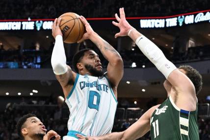 Feb 9, 2024; Milwaukee, Wisconsin, USA; Charlotte Hornets forward Miles Bridges (0) drives to the basket against Milwaukee Bucks center Brook Lopez (11) in the first half at Fiserv Forum. Mandatory Credit: Michael McLoone-USA TODAY Sports