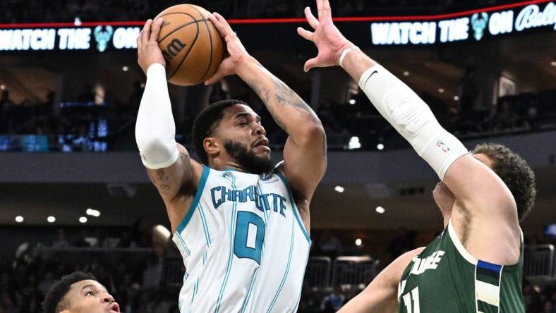 Feb 9, 2024; Milwaukee, Wisconsin, USA; Charlotte Hornets forward Miles Bridges (0) drives to the basket against Milwaukee Bucks center Brook Lopez (11) in the first half at Fiserv Forum. Mandatory Credit: Michael McLoone-USA TODAY Sports