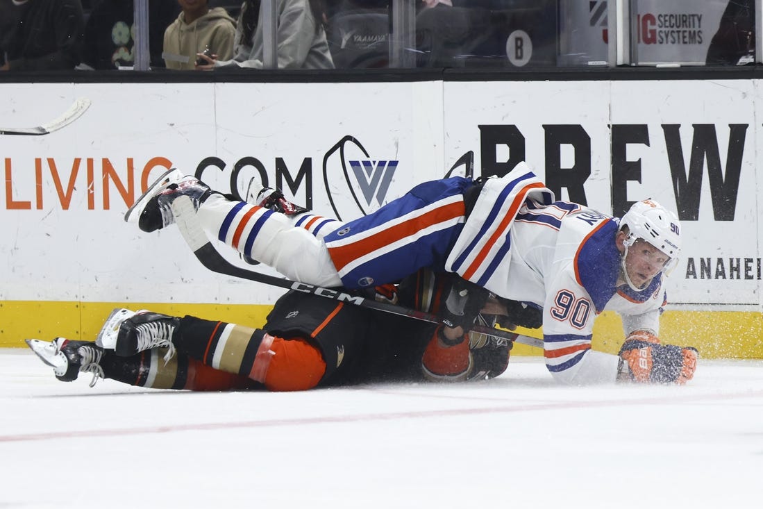 Feb 9, 2024; Anaheim, California, USA; Edmonton Oilers right wing Corey Perry (90) falls on top of an Anaheim Ducks player during the first period of a game at Honda Center. Mandatory Credit: Jessica Alcheh-USA TODAY Sports