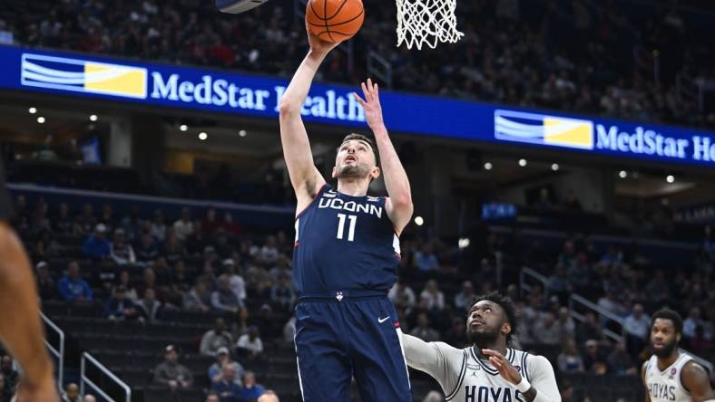 Feb 10, 2024; Washington, District of Columbia, USA; Connecticut Huskies forward Alex Karaban (11) shoots as Georgetown Hoyas guard Jay Heath (5) looks on during the first half at Capital One Arena. Mandatory Credit: Brad Mills-USA TODAY Sports