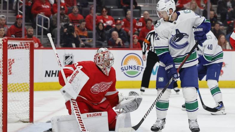 Feb 10, 2024; Detroit, Michigan, USA;  Detroit Red Wings goaltender Alex Lyon (34) makes a save in front of Vancouver Canucks center Elias Lindholm (23) in the first period at Little Caesars Arena. Mandatory Credit: Rick Osentoski-USA TODAY Sports