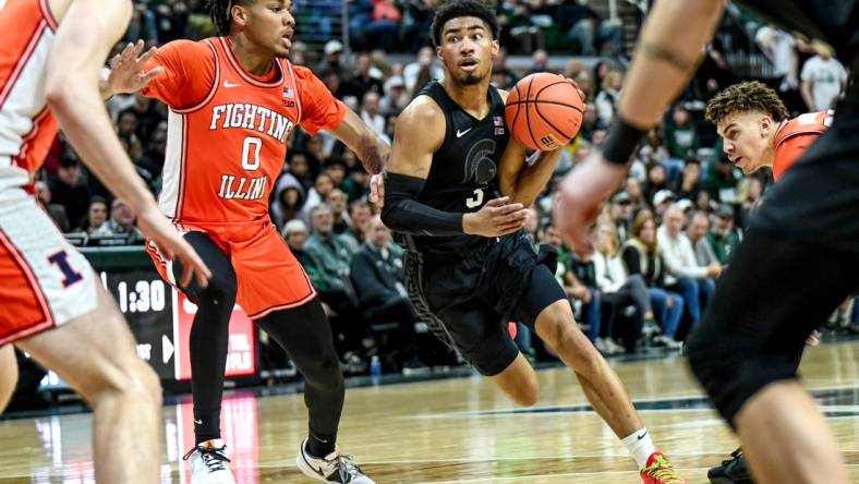 Michigan State's Jaden Akins, right, moves the ball as Illinois' Terrence Shannon Jr. defends during the first half on Saturday, Feb. 10, 2024, at the Breslin Center in East Lansing.