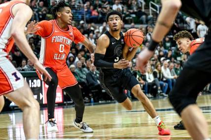 Michigan State's Jaden Akins, right, moves the ball as Illinois' Terrence Shannon Jr. defends during the first half on Saturday, Feb. 10, 2024, at the Breslin Center in East Lansing.