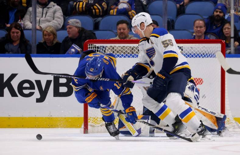 Feb 10, 2024; Buffalo, New York, USA;  Buffalo Sabres left wing Jordan Greenway (12) gets a stick in the face by St. Louis Blues defenseman Colton Parayko (55) as they go after a loose puck during the third period at KeyBank Center. Mandatory Credit: Timothy T. Ludwig-USA TODAY Sports