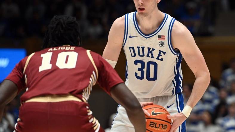 Feb 10, 2024; Durham, North Carolina, USA; Duke Blue Devils center Kyle Filipowski (30) controls the ball in front of Boston College Eagles forward Prince Aligbe (10) during the second half at Cameron Indoor Stadium. Mandatory Credit: Rob Kinnan-USA TODAY Sports