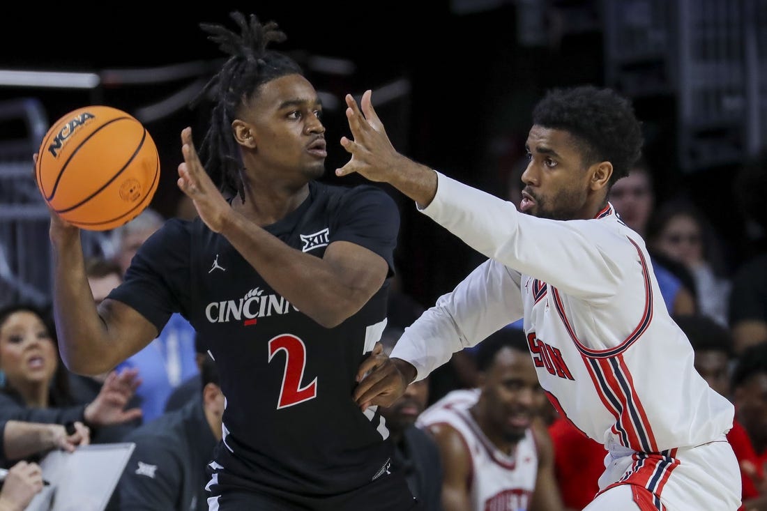 Feb 10, 2024; Cincinnati, Ohio, USA; Cincinnati Bearcats guard Jizzle James (2) holds the ball against Houston Cougars guard Mylik Wilson (8) in the first half at Fifth Third Arena. Mandatory Credit: Katie Stratman-USA TODAY Sports