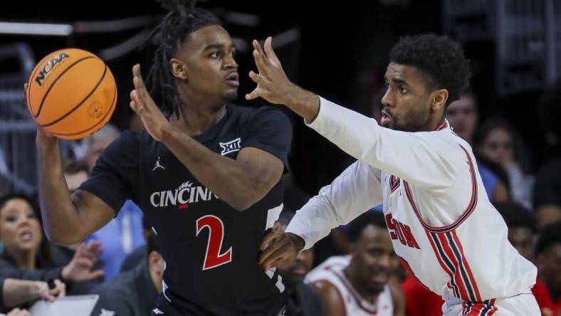 Feb 10, 2024; Cincinnati, Ohio, USA; Cincinnati Bearcats guard Jizzle James (2) holds the ball against Houston Cougars guard Mylik Wilson (8) in the first half at Fifth Third Arena. Mandatory Credit: Katie Stratman-USA TODAY Sports