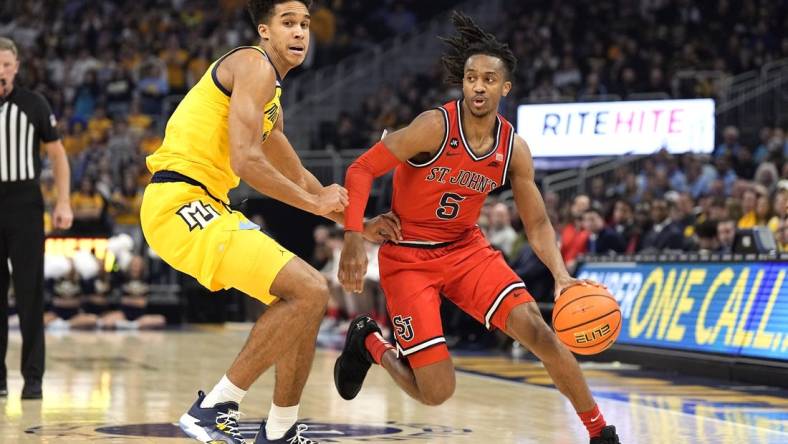 Feb 10, 2024; Milwaukee, Wisconsin, USA;  St. John's Red Storm guard Daniss Jenkins (5) drives for the basket against Marquette Golden Eagles forward Oso Ighodaro (13) during the first half at Fiserv Forum. Mandatory Credit: Jeff Hanisch-USA TODAY Sports