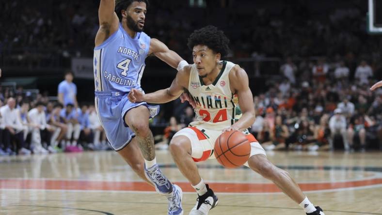 Feb 10, 2024; Coral Gables, Florida, USA; Miami Hurricanes guard Nijel Pack (24) drives to the basket past North Carolina Tar Heels guard RJ Davis (4) during the second half at Watsco Center. Mandatory Credit: Sam Navarro-USA TODAY Sports