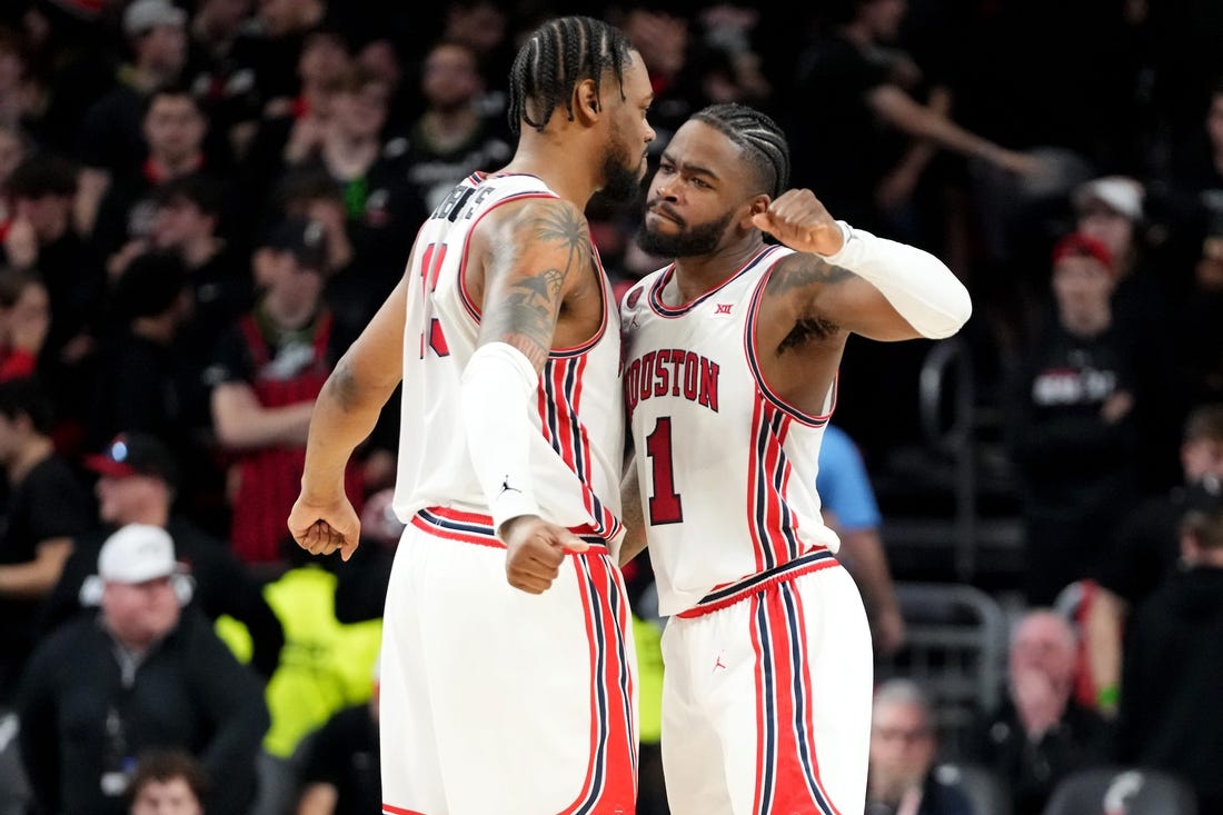 Houston Cougars forward J'Wan Roberts (13) and Houston Cougars guard Jamal Shead (1) celebrate the win at the conclusion of the second half of an NCAA college basketball game against the Cincinnati Bearcats, Saturday, Feb. 10, 2024, at Fifth Third Arena in Cincinnati.