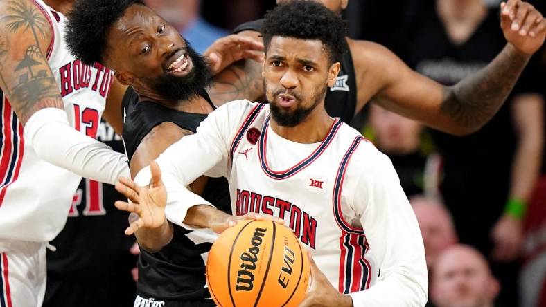 Cincinnati Bearcats forward John Newman III (15) reaches for a rebound against Houston Cougars guard Mylik Wilson (8) in the second half of an NCAA college basketball game between the Houston Cougars and the Cincinnati Bearcats, Saturday, Feb. 10, 2024, at Fifth Third Arena in Cincinnati.