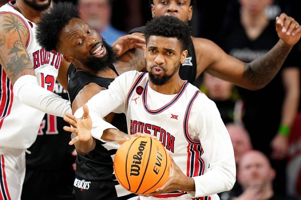 Cincinnati Bearcats forward John Newman III (15) reaches for a rebound against Houston Cougars guard Mylik Wilson (8) in the second half of an NCAA college basketball game between the Houston Cougars and the Cincinnati Bearcats, Saturday, Feb. 10, 2024, at Fifth Third Arena in Cincinnati.