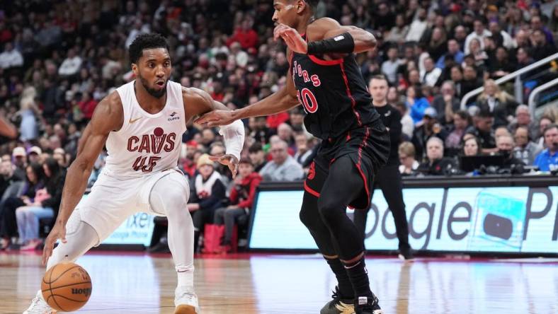 Feb 10, 2024; Toronto, Ontario, CAN; Cleveland Cavaliers guard Donovan Mitchell (45) controls the ball as Toronto Raptors guard Ochai Agbaji (30) tries to defend during the second quarter at Scotiabank Arena . Mandatory Credit: Nick Turchiaro-USA TODAY Sports