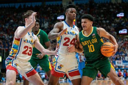 Feb 10, 2024; Lawrence, Kansas, USA; Baylor Bears guard RayJ Dennis (10) tries to get around Kansas Jayhawks forward K.J. Adams Jr. (24) and Kansas Jayhawks forward Parker Braun (23) during the first half at Allen Fieldhouse. Mandatory Credit: William Purnell-USA TODAY Sports