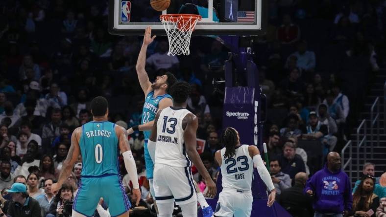 Feb 10, 2024; Charlotte, North Carolina, USA; Charlotte Hornets guard Vasilije Micic (22) with a reverse layup defended by Memphis Grizzlies guard Derrick Rose (23) during the second half at Spectrum Center. Mandatory Credit: Jim Dedmon-USA TODAY Sports