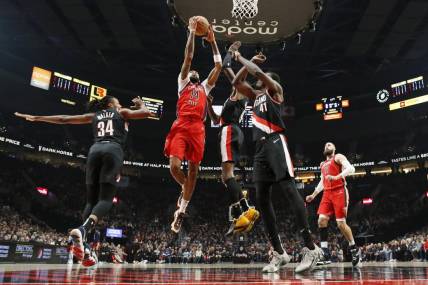 Feb 10, 2024; Portland, Oregon, USA; New Orleans Pelicans small forward Brandon Ingram (14) drives for the basket between Portland Trail Blazers forward Jabari Walker (34) and small forward Jerami Grant (9, right) during the first half at Moda Center. Mandatory Credit: Soobum Im-USA TODAY Sports