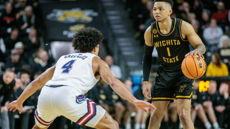 Feb 11, 2024; Wichita, Kansas, USA; Wichita State Shockers guard Xavier Bell (1) dribbles the ball against Florida Atlantic Owls guard Bryan Greenlee (4) during the first half at Charles Koch Arena. Mandatory Credit: William Purnell-USA TODAY Sports