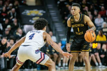 Feb 11, 2024; Wichita, Kansas, USA; Wichita State Shockers guard Xavier Bell (1) dribbles the ball against Florida Atlantic Owls guard Bryan Greenlee (4) during the first half at Charles Koch Arena. Mandatory Credit: William Purnell-USA TODAY Sports