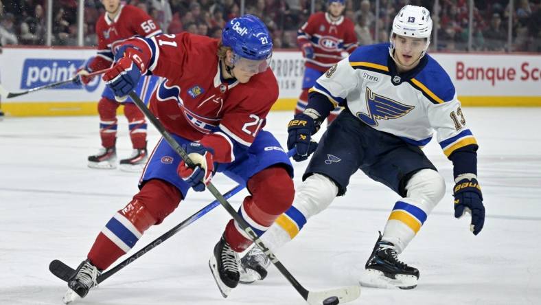 Feb 11, 2024; Montreal, Quebec, CAN; Montreal Canadiens defenseman Kaiden Guhle (21) plays the puck and St.Louis Blues forward Alexey Toropchenko (13) forechecks during the first period at the Bell Centre. Mandatory Credit: Eric Bolte-USA TODAY Sports